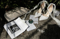 new england garden wedding ceremony flatlay with invitation and wedding shoes and wedding rings
