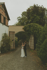 bride and groom standing down castle lane