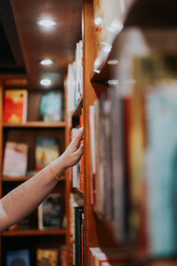 Jessie reaches for a book on a shelf.