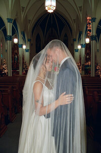 Film photo of a bride and groom under the veil.