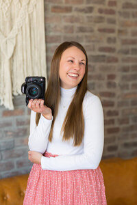 Photographer holding camera in her review of creative web design and branding for entrepreneurs with Palme Design Co
