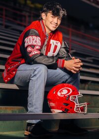 Senior Photo of Teen in Football Jacket on Bleachers