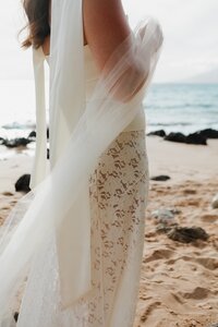 bride standing on beach in hawaii