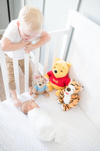 Boy looking at newborn baby taken by raleigh maternity photographer