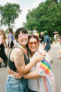 Two people hugging and smiling at pride.