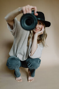 Portrait of Mandy crouching with her camera