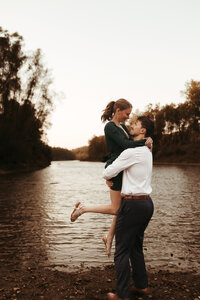 Photo of a couple hugging and having fun during their engagement photoshoot in a field in Bloomington Indiana.