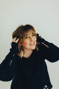 Kylee holds her hair while smiling