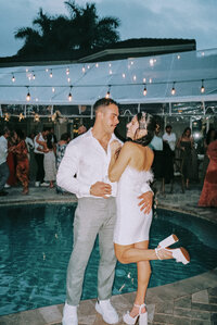 newlyweds hug in front of pool