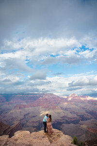 bride and groom kissing on the edge of the grand canyon