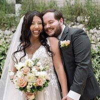 Groom hugging bride holding her bouquet at their wedding planned by Dream Weddings WI, event planners milwaukee.