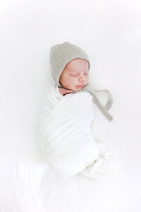 Image of newborn baby's face close up on white pillow taken by Family Photographer Sacramento Kelsey Krall