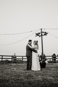 a black and white image of a bride and groom dancing