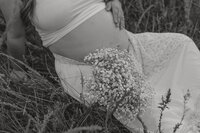 A soon to be mother expecting her first baby sitting in a grassy field at Wing Deer Park in Johnson City, TN. Michaela Crawford Photography, a cinematic maternity photographer located in Northeast, TN. 