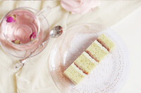 Slice of pistachio cardamom and rose cake on a pink glass plate