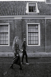 Zwart-wit foto van koppel voor huis tijdens koppelshoot, door Julia de Groot Fotografie