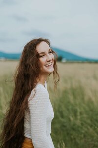 Laughing young lady in field looking free