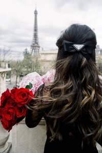 Cat Lauren Calligraphy holding roses with a Prada bow in front of the Eiffel Tower