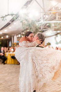 Groom carrying her bride while dancing