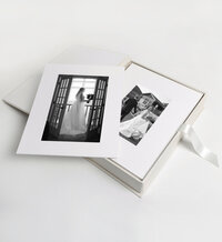 White matted photo prints of the bride on her wedding day in a custom heirloom print box with made of wood.