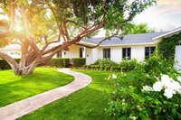 white ranch house with green lawn at sunset