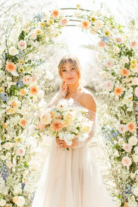 bride holding flowers in almond orchard