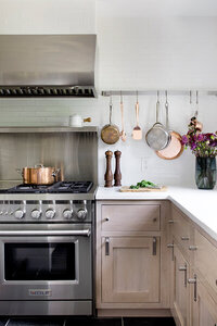 A Westwood kitchen design in Boston MA featuring light oak cabinets, a Wolf range, and a white tile backsplash in kitchen for a timeless and functional space.