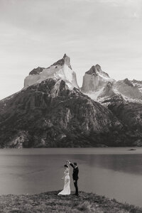 Bride and groom dancing beside a mountain lake with dramatic peaks in the background, photographed by a Pacific Northwest wedding photographer.