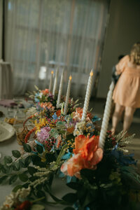 Bright florals arranged around the base of candlesticks