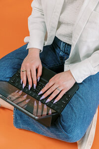 Woman cross-legged and typing on laptop