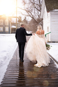 Bride and groom walking away looking at each other at Kinsmen Park in Edmonton