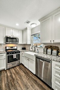 Bright and airy kitchen with stainless steel appliances at this four-bedroom, three-bathroom vacation rental home with game room, spa, and firepit located on the edge of Waco, TX.