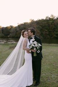 groom kissing bride next to creek virginia wedding