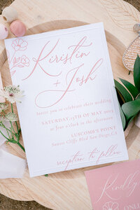 close shot of wedding invitation and rings