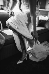 A bride puts on her wedding shoes at the Malcolm Hotel in Canmore, Alberta