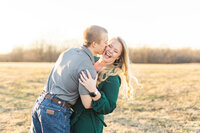 A winter engagement session in a field at sunset on a private residence.