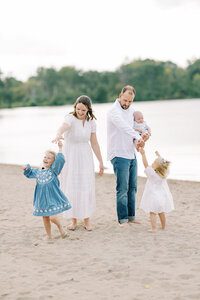 Family of 5 dancing together on the beach. 
