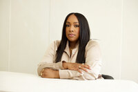 woman sitting at white desk with hands crossed