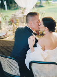 wedding couple kissing at reception table