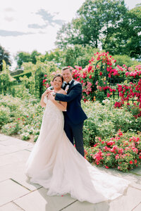 A newlywed standing behind their partner with their arms wrapped around them 
