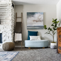 A cushioned storage bench with blue and white pillows