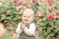 One year old boy clapping hands and smiling at camera at the Portland International Rose Test Gardens