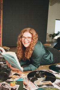 Allison Bolin Texas wedding photographer laying on the ground with a book surrounded by cameras and records