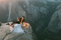 man holding lantern while spinning woman  on mountaintop