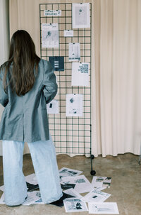 Womabranding n with her back turned looking at branding information in a website design studio