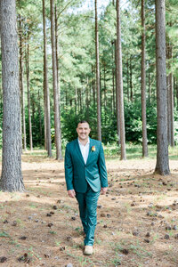 A groom walking in a wooded area