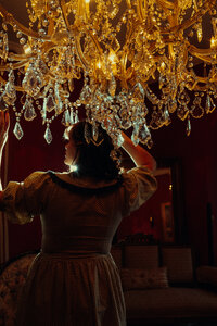 Kenna stands under a gorgeous crystal chandelier.