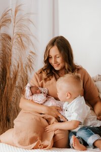 mom poses with baby and son during family photos in peoria il