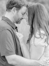 Father and mother holding each other close with their heads together.