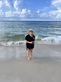 photo of jennifer mosier photographer holding a camera at the beach in Gulf Shores on vacation